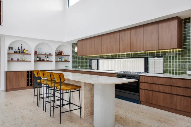 Modern kitchen with bar counter and stools.