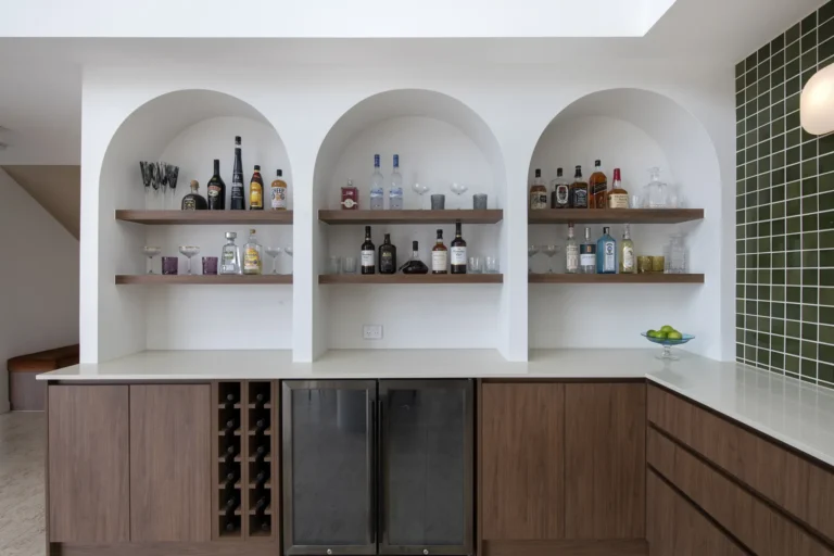 Modern home bar with shelves of bottles.