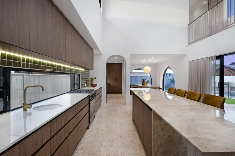 Modern kitchen with marble island and wood cabinets.