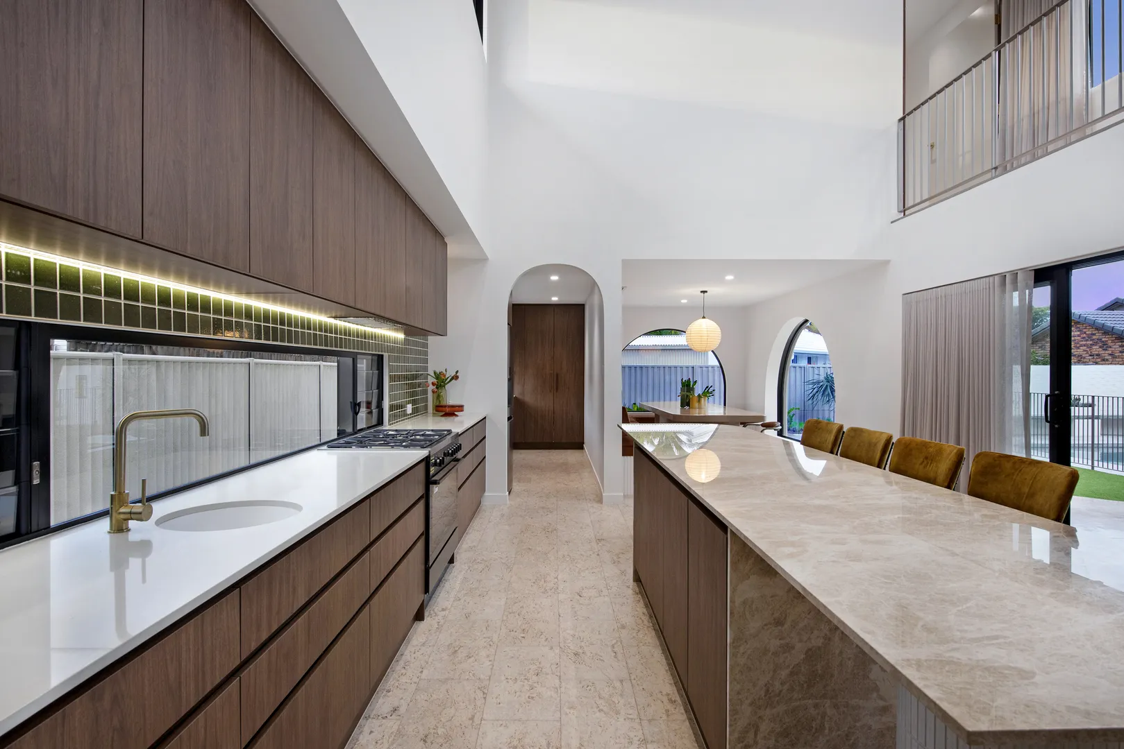 Modern kitchen with marble island and wood cabinets.