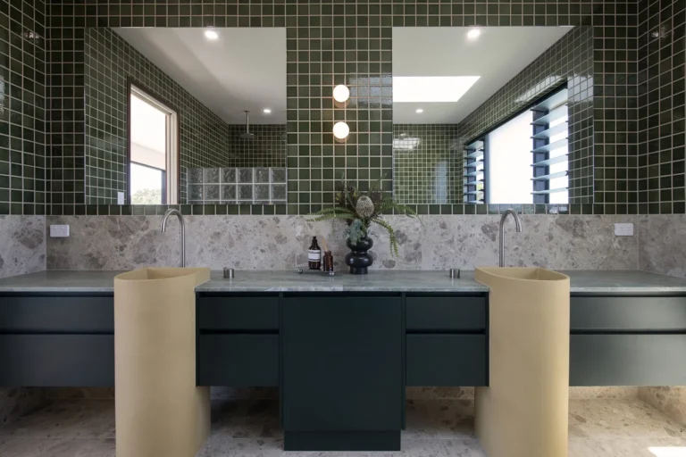 Modern bathroom with green tiles and double vanity.