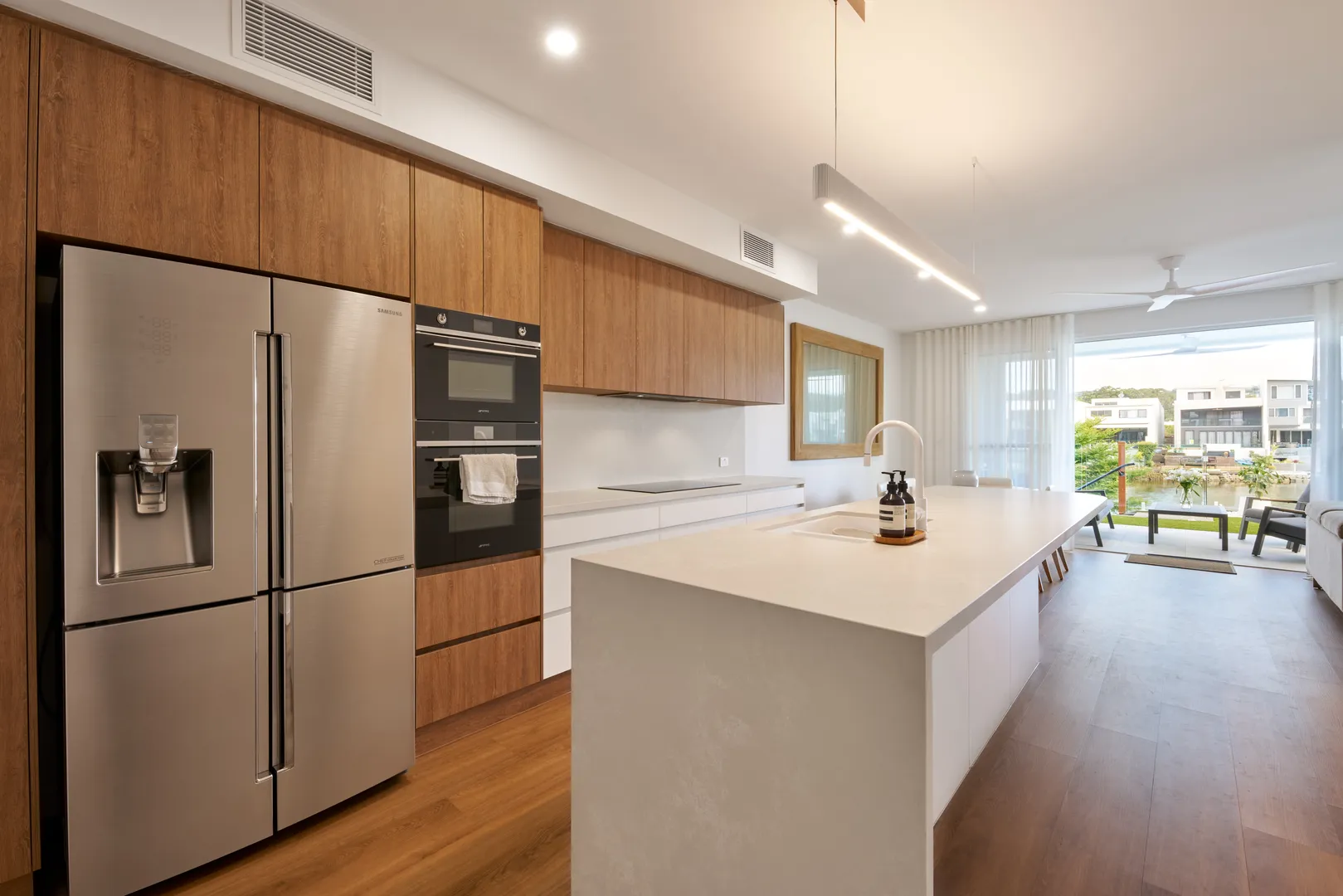 Modern kitchen with island, stainless appliances, and outdoor view.