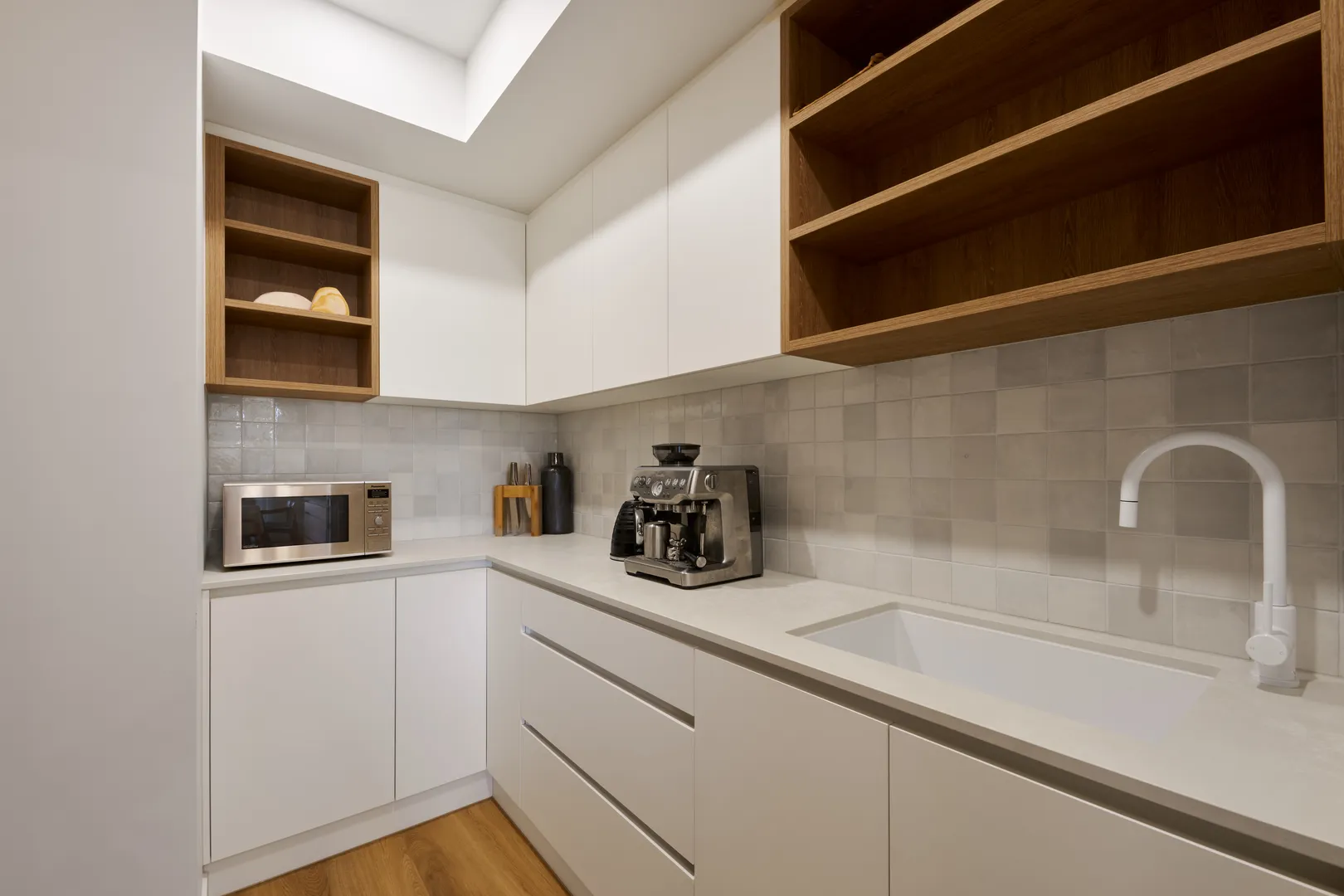 Modern kitchen with white cabinets and appliances.