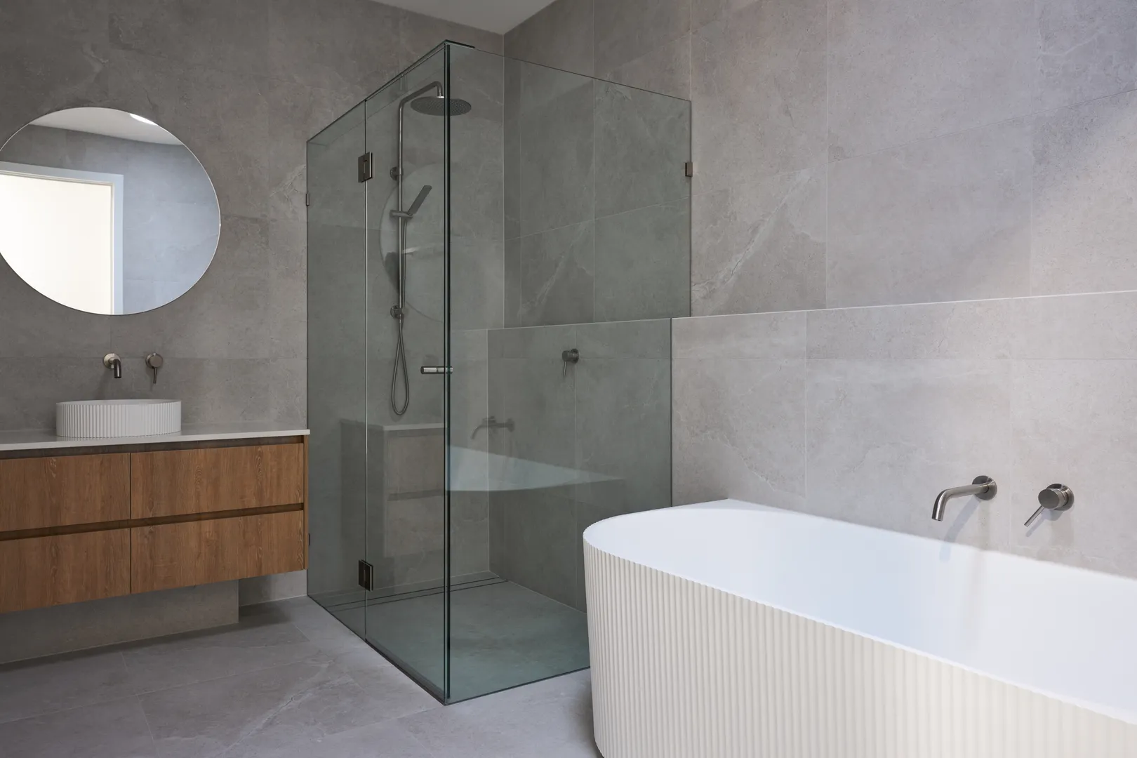 Modern bathroom with glass shower and bathtub.