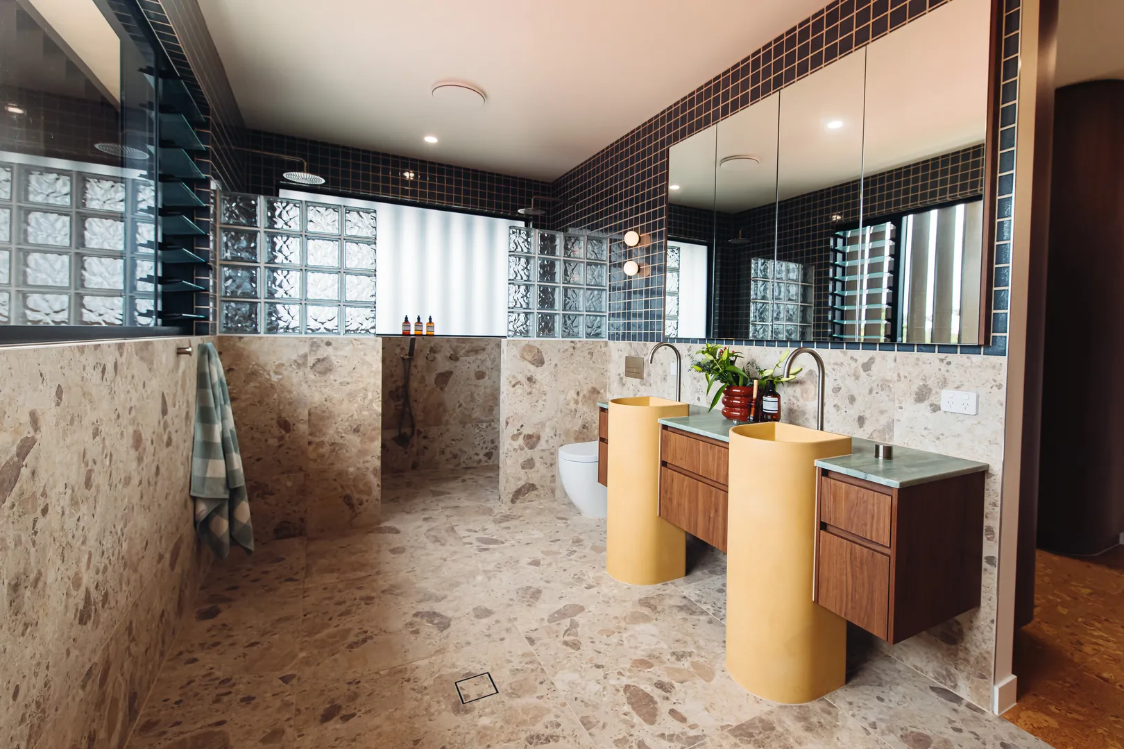 Modern bathroom with double sinks and tiled walls.